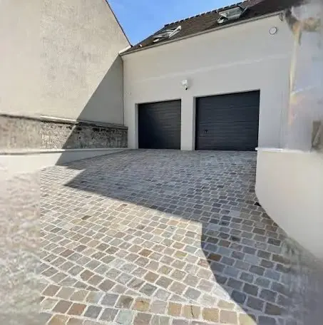 Cour pavée en pierre naturelle devant un garage