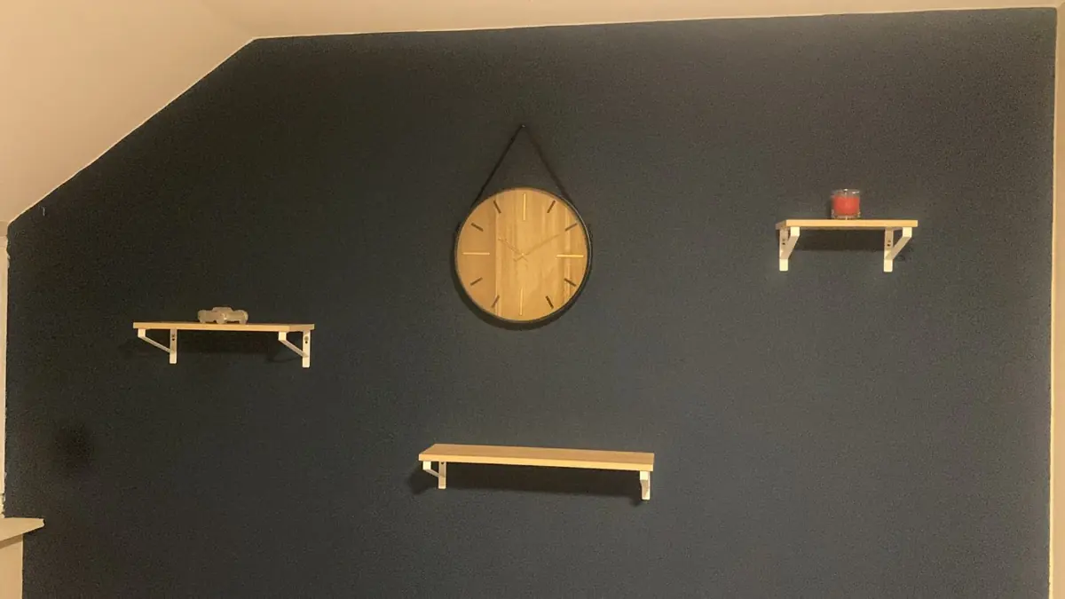 Mur anthracite avec miroir rond et étagères
