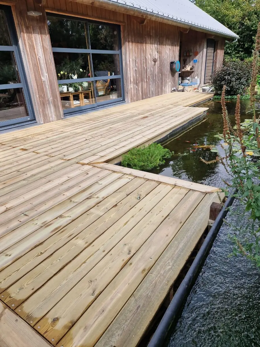 Terrasse en bois contre un bardage bois au-dessus d'un bassin